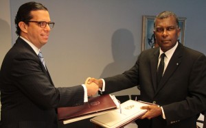 Frederick Mitchell y César Dargam estrechan sus manos luego de la firma del acuerdo.
