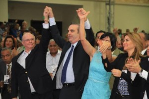 Hipólito Mejía y Luis Abinader levantan sus manos junto a otros dirigentes.