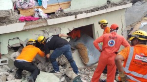 Brigadistas buscan entre los escombros.