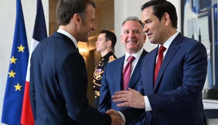 Emmanuel Macron y Marco Rubio mientras se saludan.