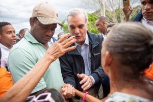 Abinader saluda una mujer durante recorrido en zonas afectadas por las lluvias en Los Alcarrizos.