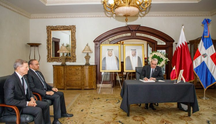 Abinader cuando firma libro en la embajada de Qatar.