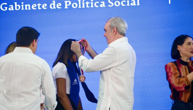 Abinader entrega medalla a joven graduada.
