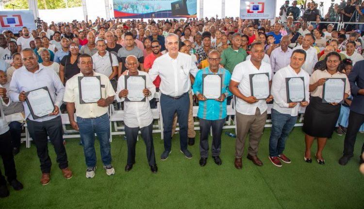 Abinader junto a algunos de los beneficiarios con títulos en Los Alcarrizos.